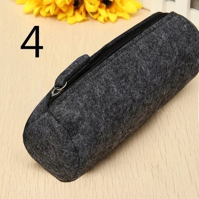 Gray felt pencil case on a beige surface with yellow flowers in the background